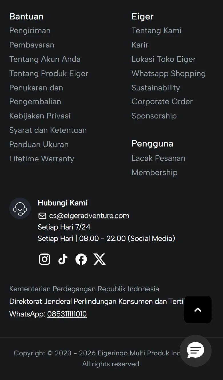 Tangkapan layar footer situs Eiger di layar ponsel selebar 390 piksel: kolom Bantuan dan kolom Eiger tetap berdampingan, kolom Pengguna di bawah kolom Eiger, lalu blok Hubungi Kami berisi email, jam layanan, dan ikon media sosial, kontak pengaduan konsumen yang sebagian tertutup tombol kembali ke atas, tombol chat mengambang, dan baris hak cipta